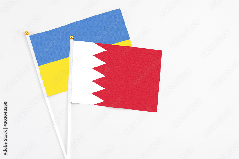 Bahrain and Ukraine stick flags on white background. High quality fabric, miniature national flag. Peaceful global concept.White floor for copy space. Bahrain and Ukraine stick flags on white background. High quality fabric, miniature national flag. Peaceful global concept.White floor for copy space.