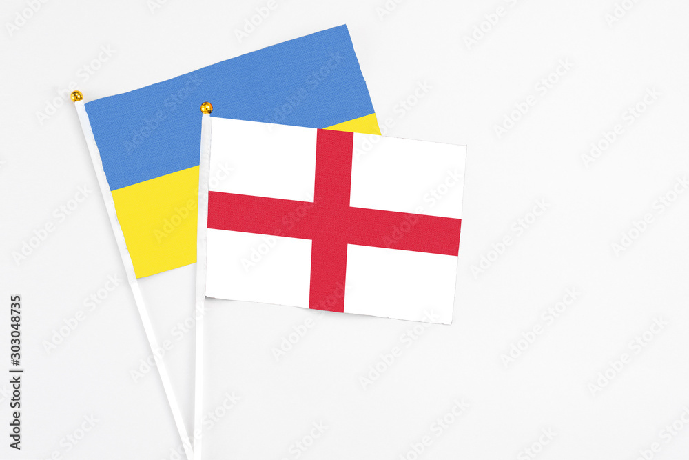 England and Ukraine stick flags on white background. High quality fabric, miniature national flag. Peaceful global concept.White floor for copy space.