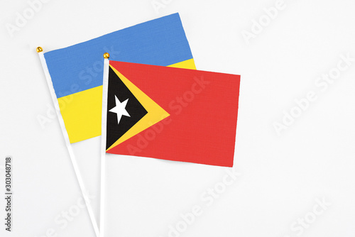 Free Download East Timor and Ukraine stick flags on white background. High quality fabric, miniature national flag. Peaceful global concept.White floor for copy space. - GFXLoad