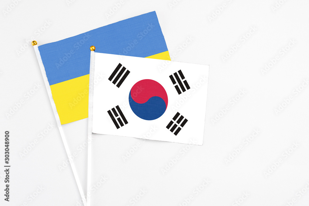 South Korea and Ukraine stick flags on white background. High quality fabric, miniature national flag. Peaceful global concept.White floor for copy space. South Korea and Ukraine stick flags on white background. High quality fabric, miniature national flag. Peaceful global concept.White floor for copy space.