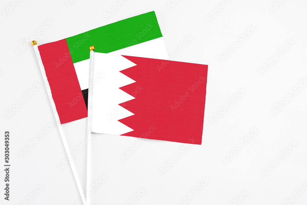 Bahrain and United Arab Emirates stick flags on white background. High quality fabric, miniature national flag. Peaceful global concept.White floor for copy space. Bahrain and United Arab Emirates stick flags on white background. High quality fabric, miniature national flag. Peaceful global concept.White floor for copy space.
