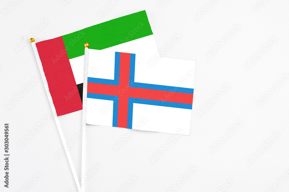 Faroe Islands and United Arab Emirates stick flags on white background. High quality fabric, miniature national flag. Peaceful global concept.White floor for copy space.