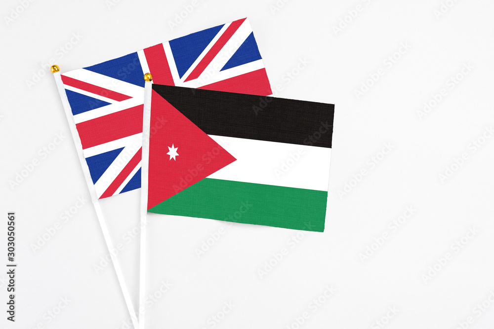 Jordan and United Kingdom stick flags on white background. High quality fabric, miniature national flag. Peaceful global concept.White floor for copy space. Jordan and United Kingdom stick flags on white background. High quality fabric, miniature national flag. Peaceful global concept.White floor for copy space.