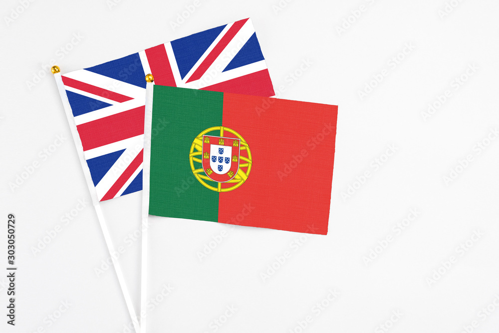 Portugal and United Kingdom stick flags on white background. High quality fabric, miniature national flag. Peaceful global concept.White floor for copy space. Portugal and United Kingdom stick flags on white background. High quality fabric, miniature national flag. Peaceful global concept.White floor for copy space.