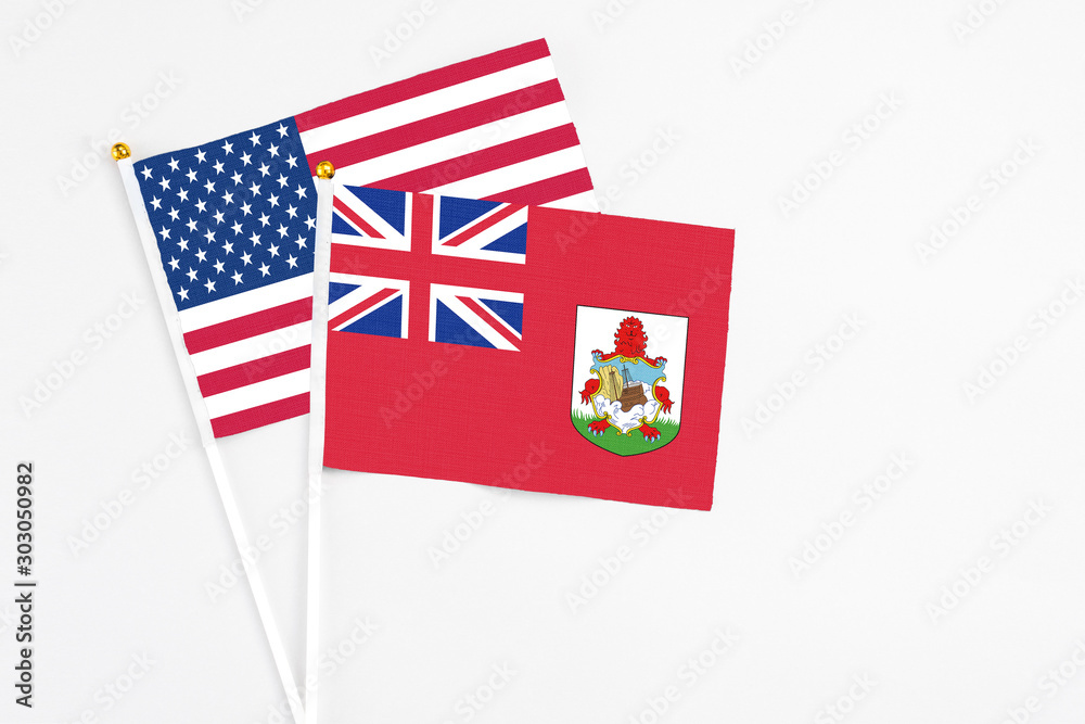Bermuda and United States stick flags on white background. High quality fabric, miniature national flag. Peaceful global concept.White floor for copy space.