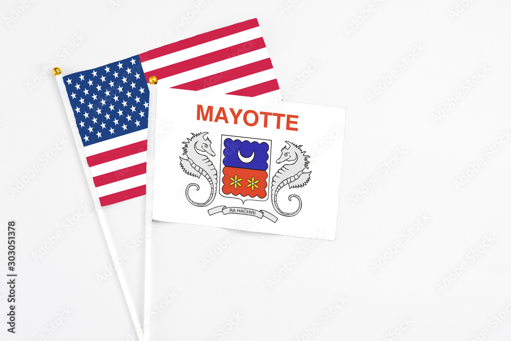 Mayotte and United States stick flags on white background. High quality fabric, miniature national flag. Peaceful global concept.White floor for copy space. Mayotte and United States stick flags on white background. High quality fabric, miniature national flag. Peaceful global concept.White floor for copy space.