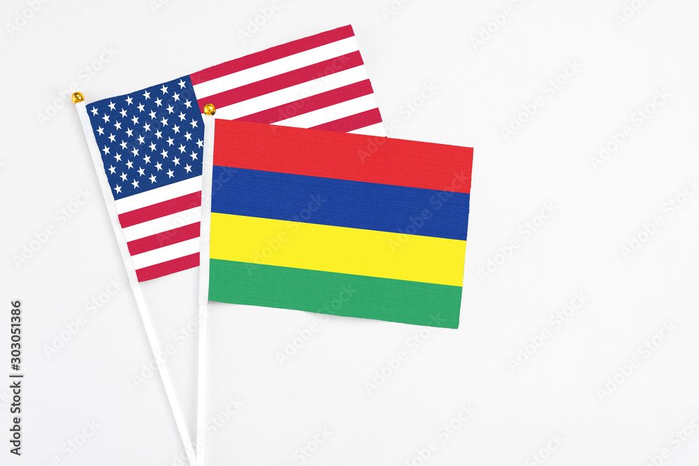 Mauritius and United States stick flags on white background. High quality fabric, miniature national flag. Peaceful global concept.White floor for copy space. Mauritius and United States stick flags on white background. High quality fabric, miniature national flag. Peaceful global concept.White floor for copy space.