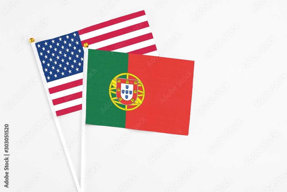 Portugal and United States stick flags on white background. High quality fabric, miniature national flag. Peaceful global concept.White floor for copy space.