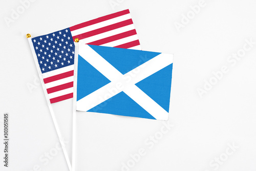 Scotland and United States stick flags on white background. High quality fabric, miniature national flag. Peaceful global concept.White floor for copy space.