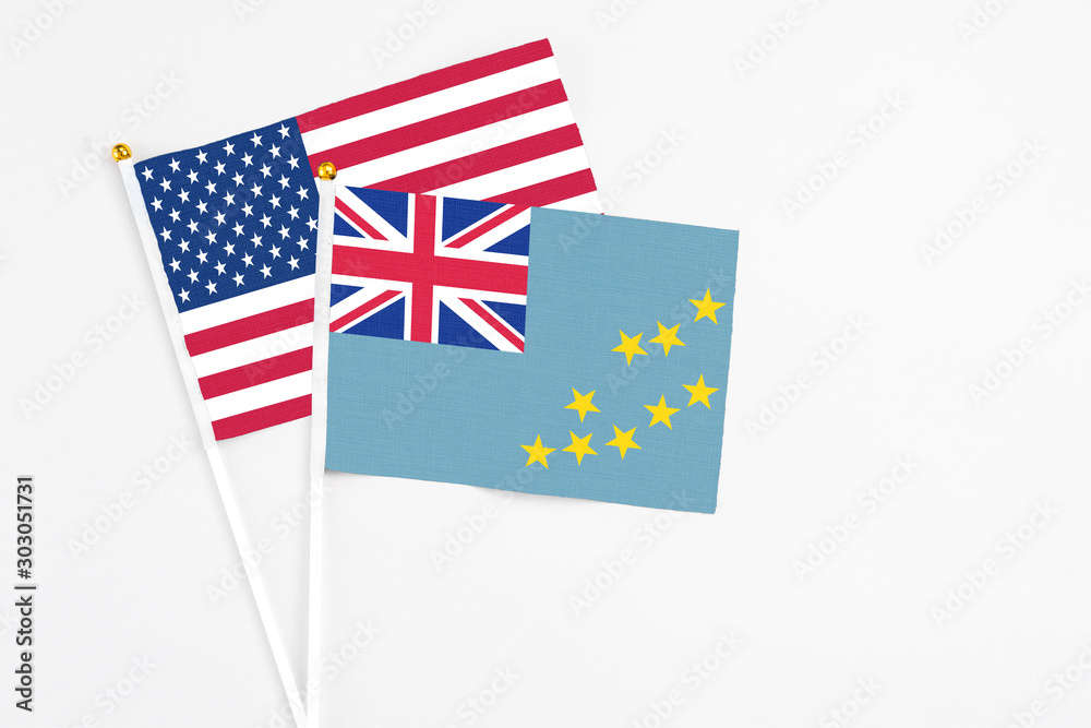 Tuvalu and United States stick flags on white background. High quality fabric, miniature national flag. Peaceful global concept.White floor for copy space. Tuvalu and United States stick flags on white background. High quality fabric, miniature national flag. Peaceful global concept.White floor for copy space.