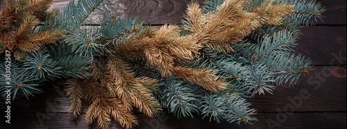 Christmas fir branches on old dark wooden background