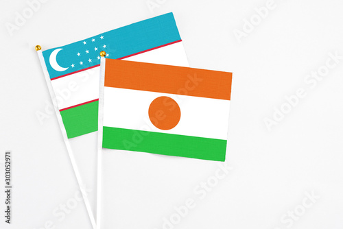 Free Download Niger and Uzbekistan stick flags on white background. High quality fabric, miniature national flag. Peaceful global concept.White floor for copy space. - GFXLoad