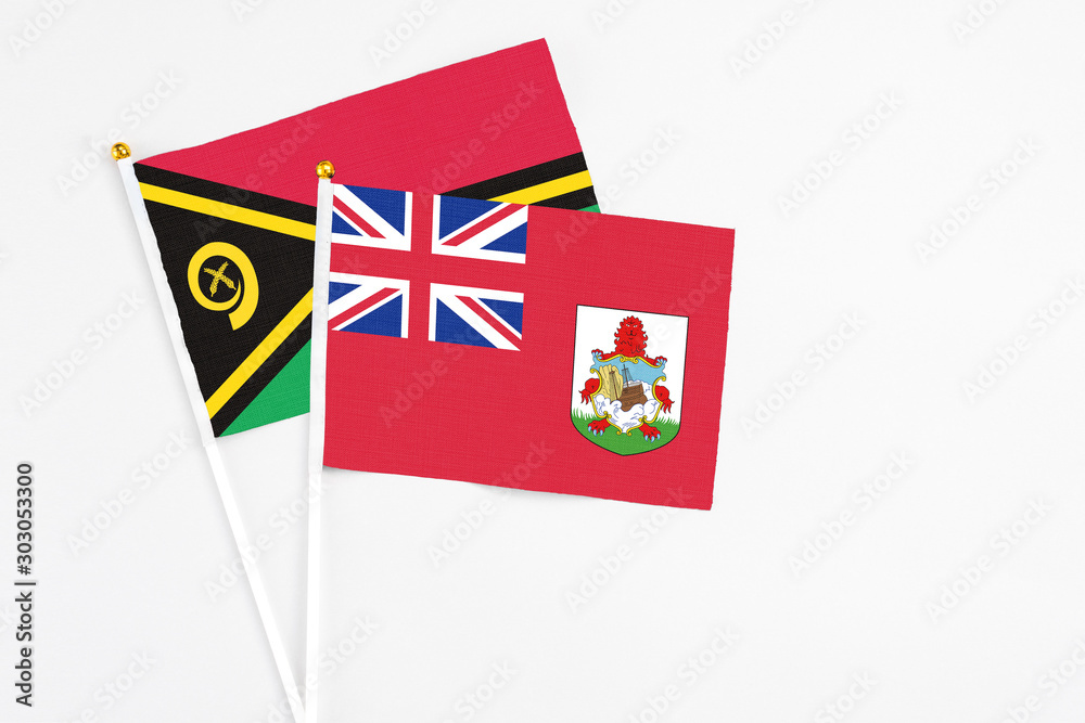Fototapeta premium Bermuda and Vanuatu stick flags on white background. High quality fabric, miniature national flag. Peaceful global concept.White floor for copy space.