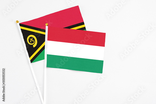 Hungary and Vanuatu stick flags on white background. High quality fabric  miniature national flag. Peaceful global concept.White floor for copy space.