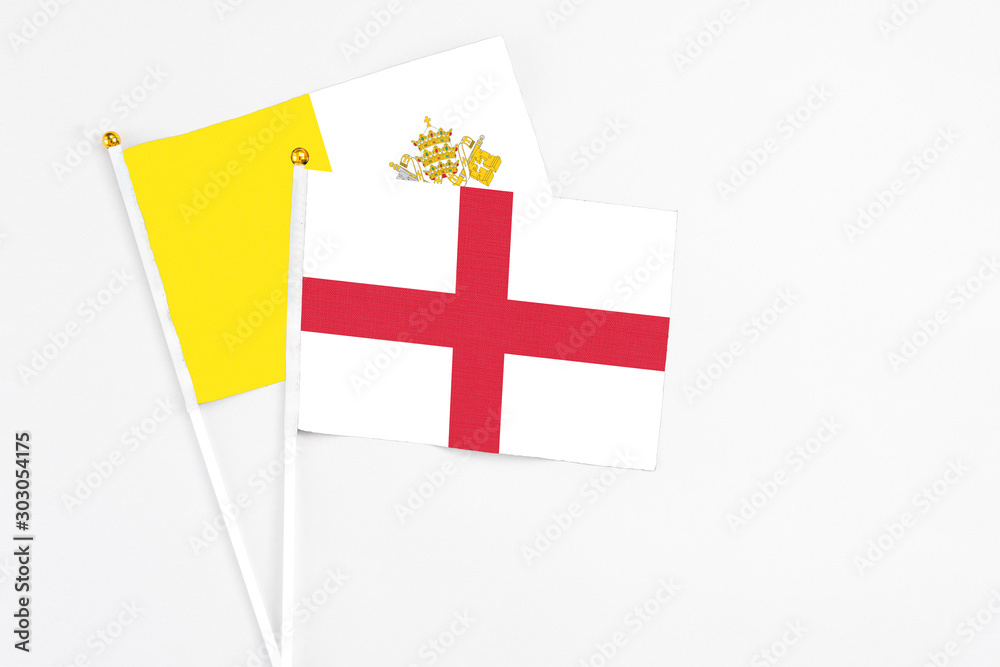 England and Vatican City stick flags on white background. High quality fabric, miniature national flag. Peaceful global concept.White floor for copy space.