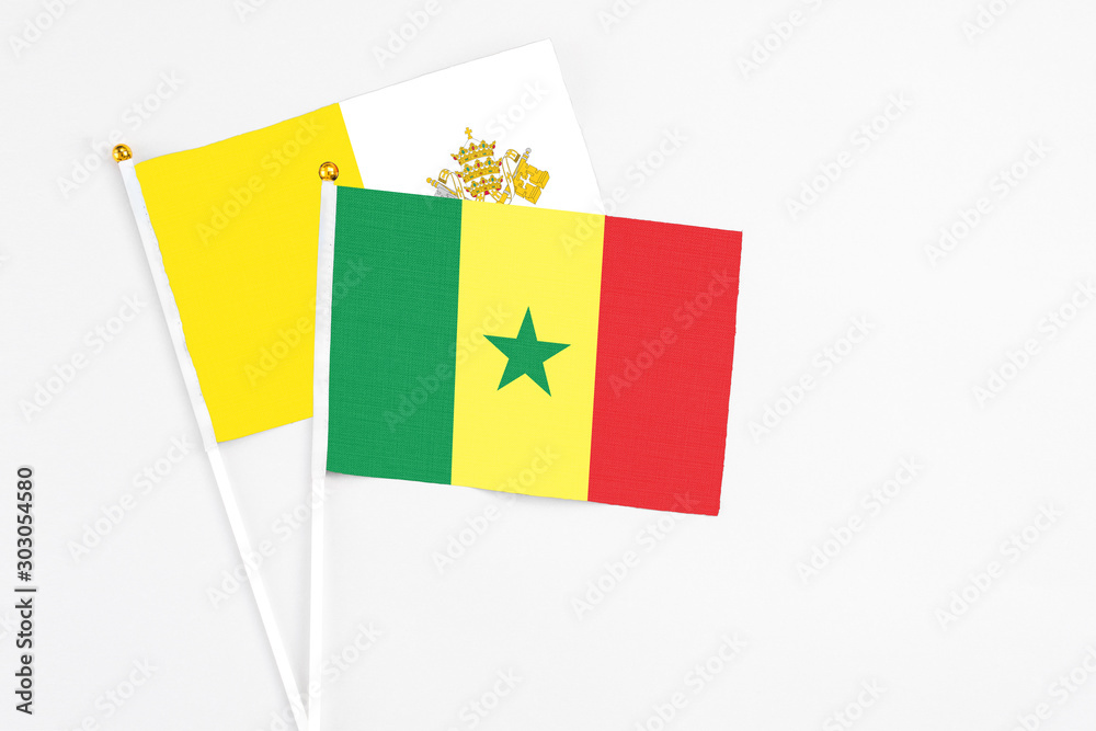 Senegal and Vatican City stick flags on white background. High quality fabric, miniature national flag. Peaceful global concept.White floor for copy space. Senegal and Vatican City stick flags on white background. High quality fabric, miniature national flag. Peaceful global concept.White floor for copy space.