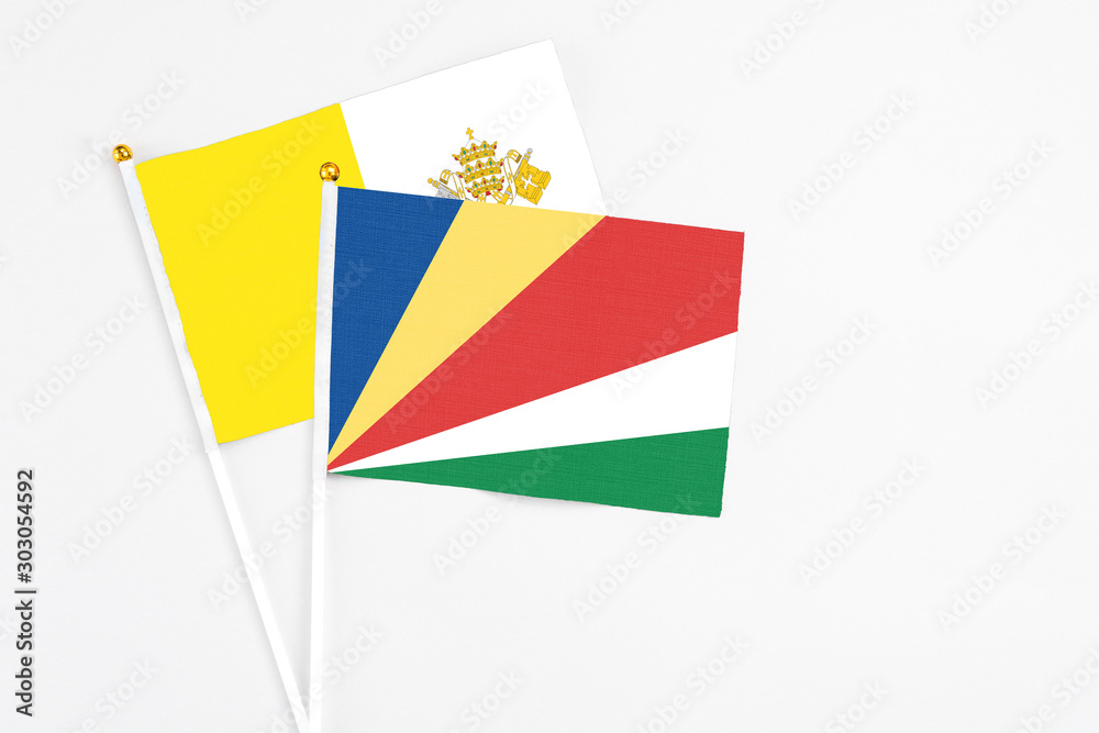 Seychelles and Vatican City stick flags on white background. High quality fabric, miniature national flag. Peaceful global concept.White floor for copy space.