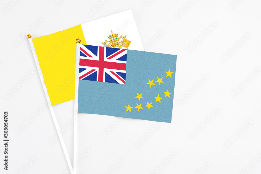 Tuvalu and Vatican City stick flags on white background. High quality fabric, miniature national flag. Peaceful global concept.White floor for copy space. Tuvalu and Vatican City stick flags on white background. High quality fabric, miniature national flag. Peaceful global concept.White floor for copy space.