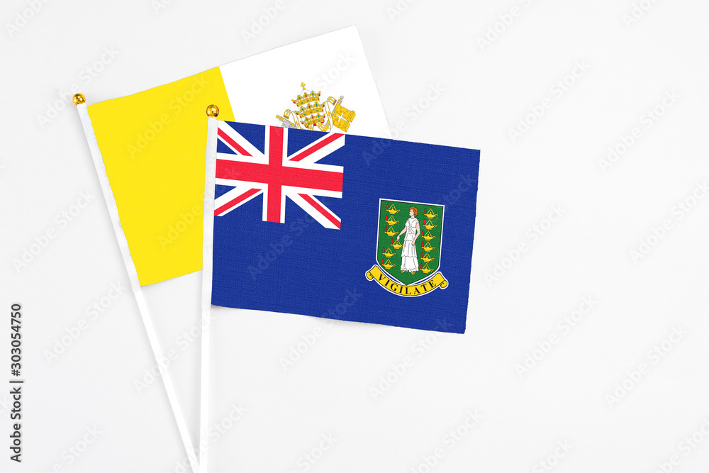 Fototapeta premium British Virgin Islands and Vatican City stick flags on white background. High quality fabric, miniature national flag. Peaceful global concept.White floor for copy space.