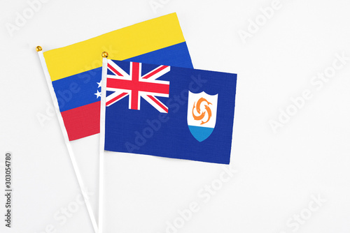 Anguilla and Venezuela stick flags on white background. High quality fabric, miniature national flag. Peaceful global concept.White floor for copy space.
