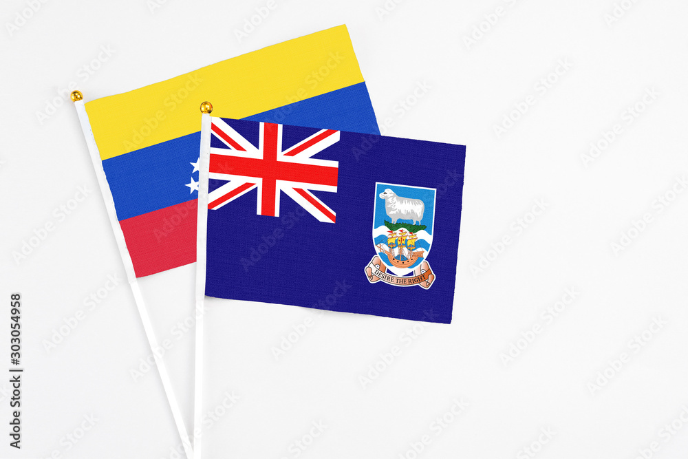 Fototapeta premium Falkland Islands and Venezuela stick flags on white background. High quality fabric, miniature national flag. Peaceful global concept.White floor for copy space.