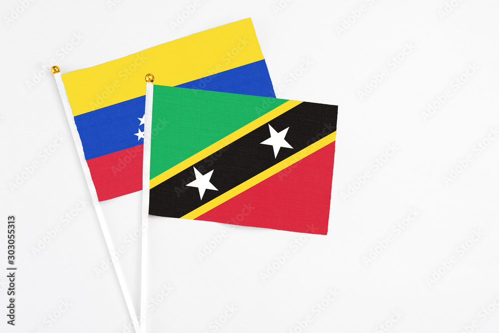 Saint Kitts And Nevis and Venezuela stick flags on white background. High quality fabric, miniature national flag. Peaceful global concept.White floor for copy space. Saint Kitts And Nevis and Venezuela stick flags on white background. High quality fabric, miniature national flag. Peaceful global concept.White floor for copy space.