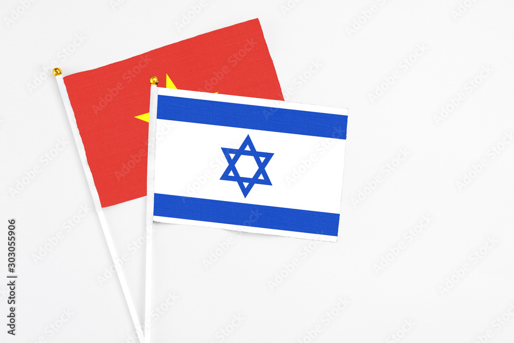 Israel and Vietnam stick flags on white background. High quality fabric, miniature national flag. Peaceful global concept.White floor for copy space. Israel and Vietnam stick flags on white background. High quality fabric, miniature national flag. Peaceful global concept.White floor for copy space.