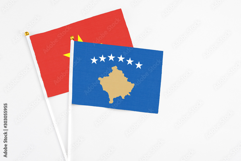 Kosovo and Vietnam stick flags on white background. High quality fabric, miniature national flag. Peaceful global concept.White floor for copy space. Kosovo and Vietnam stick flags on white background. High quality fabric, miniature national flag. Peaceful global concept.White floor for copy space.