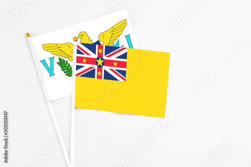 Niue and United States Virgin Islands stick flags on white background. High quality fabric, miniature national flag. Peaceful global concept.White floor for copy space.