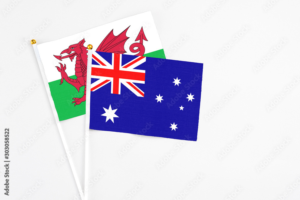Fototapeta premium Australia and Wales stick flags on white background. High quality fabric, miniature national flag. Peaceful global concept.White floor for copy space.