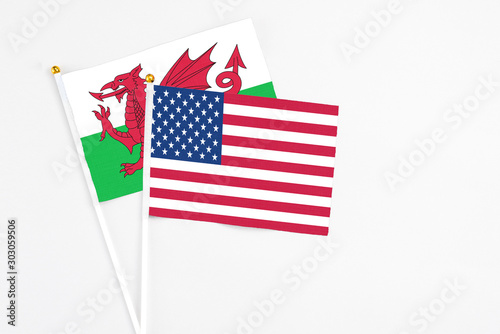 United States and Wales stick flags on white background. High quality fabric, miniature national flag. Peaceful global concept.White floor for copy space. © sezerozger