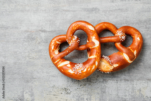 Freshly baked bavarian pretzel with salt on rustic table. photo