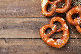 Freshly baked bavarian pretzel with salt on rustic table.
