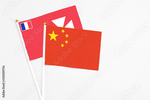 China and Wallis And Futuna stick flags on white background. High quality fabric, miniature national flag. Peaceful global concept.White floor for copy space.