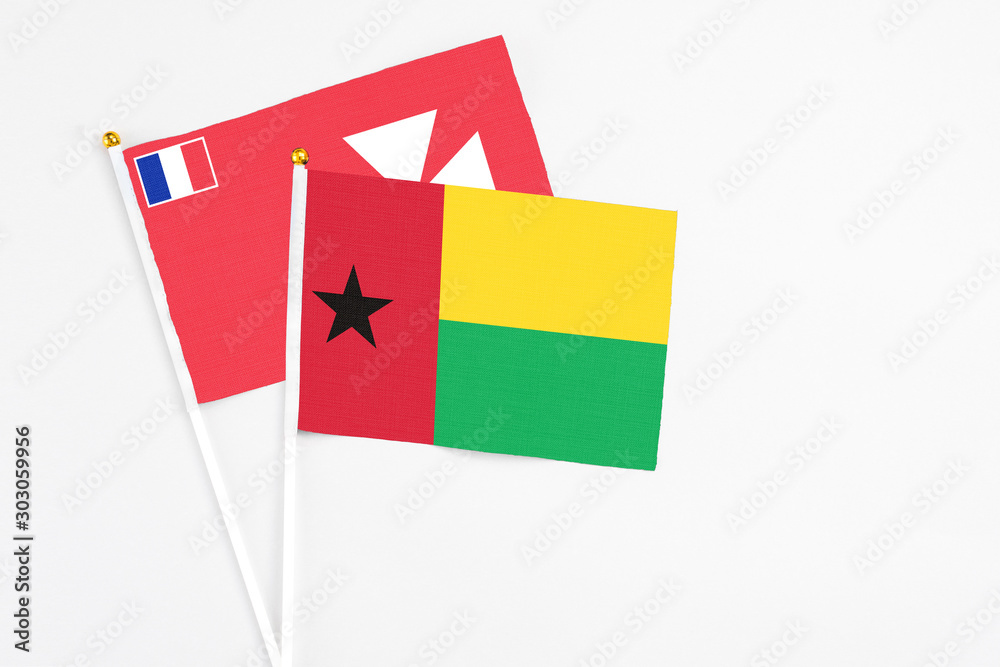 Guinea Bissau and Wallis And Futuna stick flags on white background. High quality fabric, miniature national flag. Peaceful global concept.White floor for copy space. Guinea Bissau and Wallis And Futuna stick flags on white background. High quality fabric, miniature national flag. Peaceful global concept.White floor for copy space.