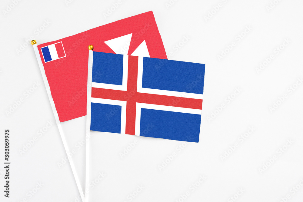Iceland and Wallis And Futuna stick flags on white background. High quality fabric, miniature national flag. Peaceful global concept.White floor for copy space.