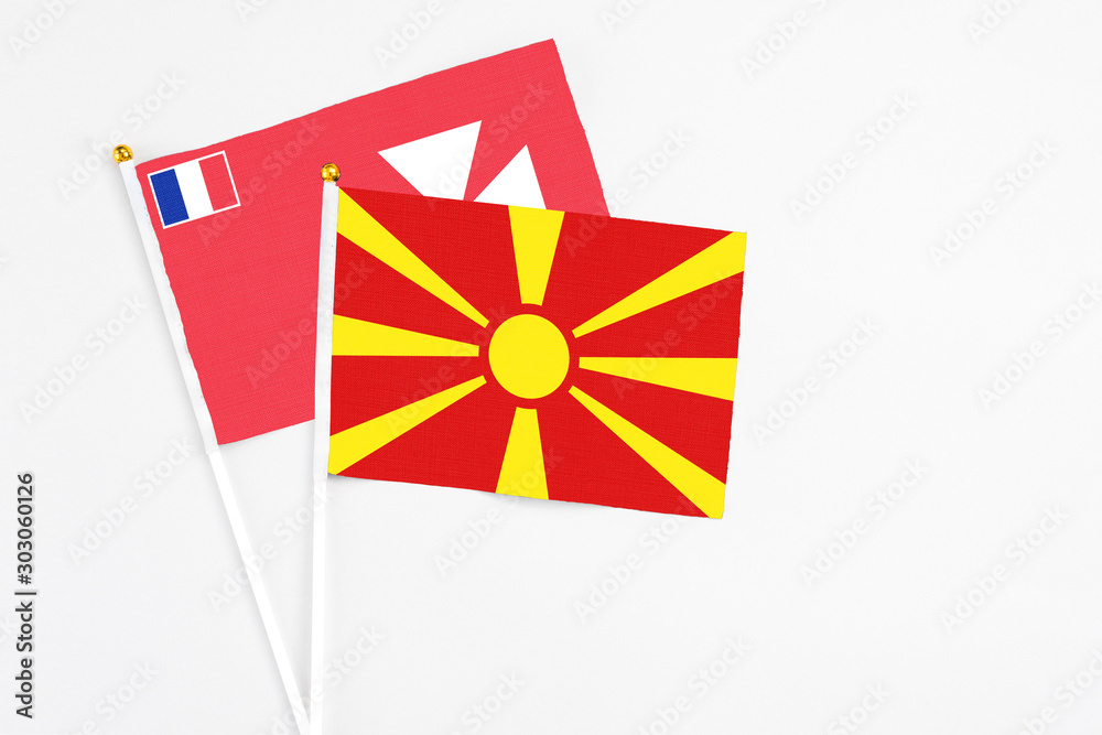 Macedonia and Wallis And Futuna stick flags on white background. High quality fabric, miniature national flag. Peaceful global concept.White floor for copy space.