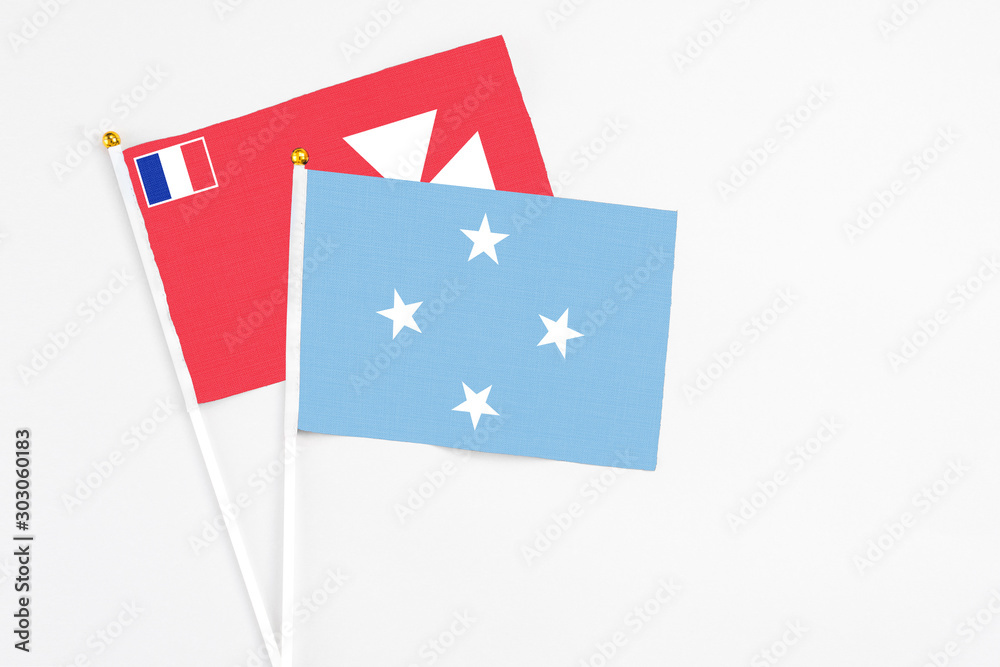 Micronesia and Wallis And Futuna stick flags on white background. High quality fabric, miniature national flag. Peaceful global concept.White floor for copy space. Micronesia and Wallis And Futuna stick flags on white background. High quality fabric, miniature national flag. Peaceful global concept.White floor for copy space.