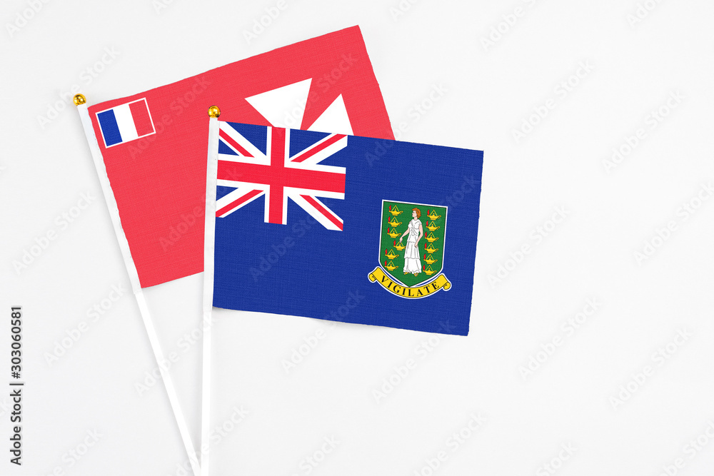 Fototapeta premium British Virgin Islands and Wallis And Futuna stick flags on white background. High quality fabric, miniature national flag. Peaceful global concept.White floor for copy space.