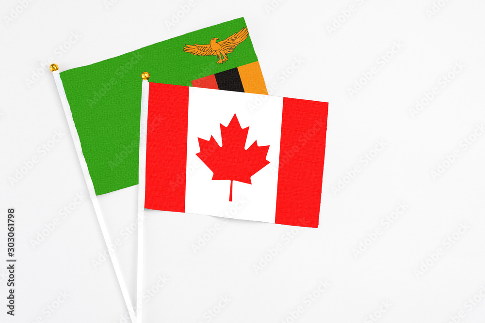 Canada and Zambia stick flags on white background. High quality fabric, miniature national flag. Peaceful global concept.White floor for copy space. Canada and Zambia stick flags on white background. High quality fabric, miniature national flag. Peaceful global concept.White floor for copy space.