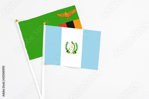 Guatemala and Zambia stick flags on white background. High quality fabric, miniature national flag. Peaceful global concept.White floor for copy space.