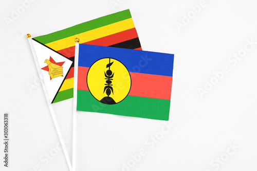 New Caledonia and Zimbabwe stick flags on white background. High quality fabric, miniature national flag. Peaceful global concept.White floor for copy space. Free Download New Caledonia and Zimbabwe stick flags on white background. High quality fabric, miniature national flag. Peaceful global concept.White floor for copy space. - GFXLoad