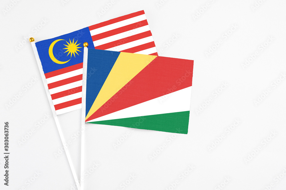Seychelles and Malaysia stick flags on white background. High quality fabric, miniature national flag. Peaceful global concept.White floor for copy space.