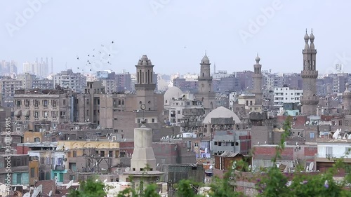 Muizz street's famous mosques with Cairo skyline, Egypt. Muizz is one of the oldest streets in Cairo which has the greatest concentration of medieval architectural treasures in the Islamic world photo