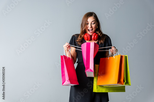 Cheerful happy woman enjoying shopping with gray background