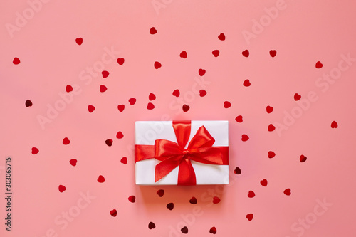 Present with red bow on pink background with copy space.