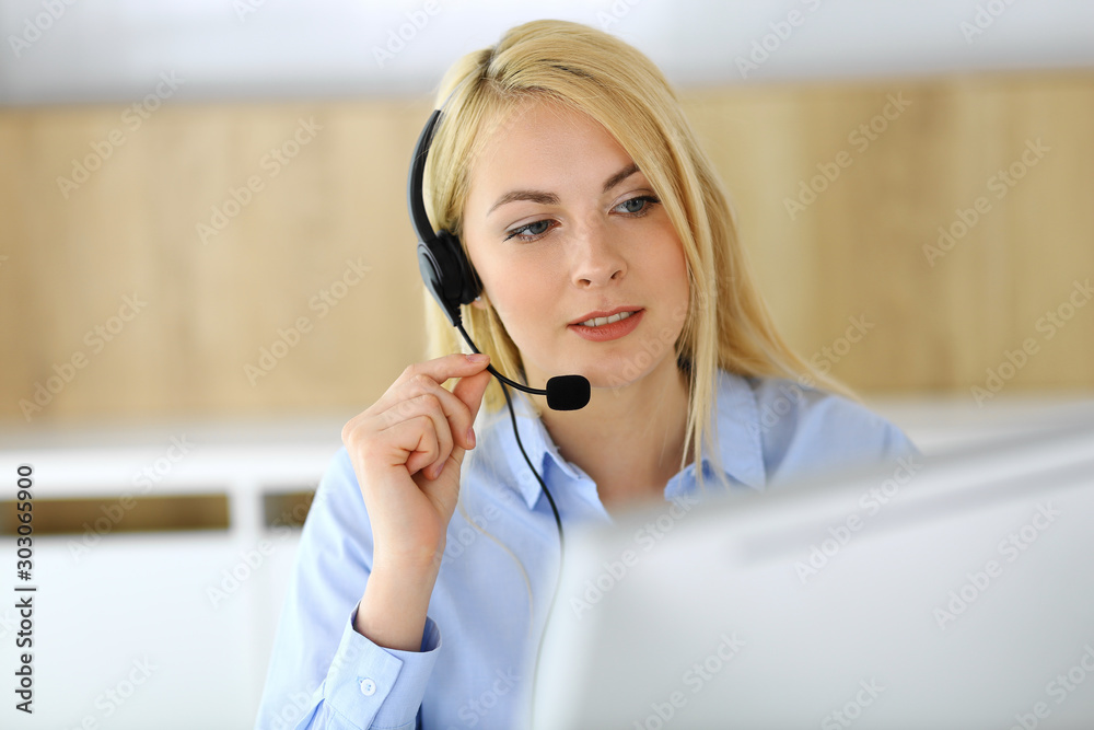Call center. Blonde business woman sitting in headset at customer service office. Concept of telesales business or home office occupation Call center. Blonde business woman sitting in headset at customer service office. Concept of telesales business or home office occupation