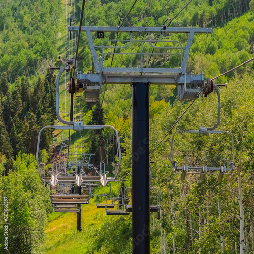 Square Chairlifts over abundant green trees and hiking trails during off season months