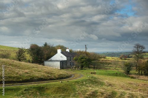 Small White farm into the valey in Ireland with a nice colourful sky scene 