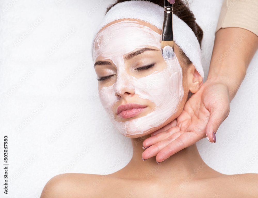 Woman receiving facial mask at beauty salon - obrazy, fototapety, plakaty 